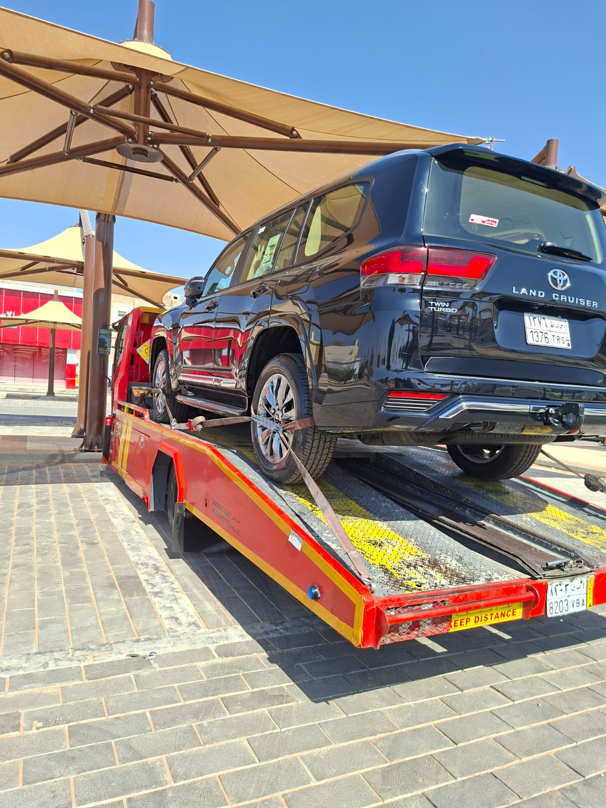 سطحة هيدروليك حمراء تنقل سيارة BMW فاخرة في الطائف